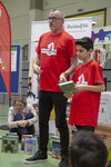 Foto: Herr Reifenberg und ein Junge aus der Klasse stellen dem Publikum ein Buch vor