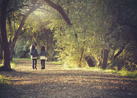 Foto: zwei Kinder gehen Hand in Hand einen Waldweg entlang