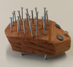 Foto: ein stilisierter Igel, gefertigt aus einem bearbeiteten Stück Holz, Korkscheiben und vielen Nägeln