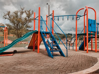 Foto: Ein Kind auf dem Spielplatz einer Schule sitzt auf der Leiter einer Rutsche