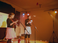 Foto: zwei Schülerinnen beim Poetry-Slam-Vortrag auf der Bühne