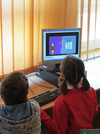 Grundschul-Kinder vor einem Desktop-PC