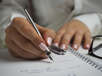 junge Frau schreibt mit einem Füller in ein Ringbuch
